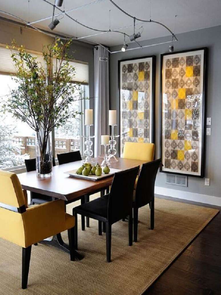5. Sala de jantar com estilo moderno decorada com quadros grandes e spots de luz