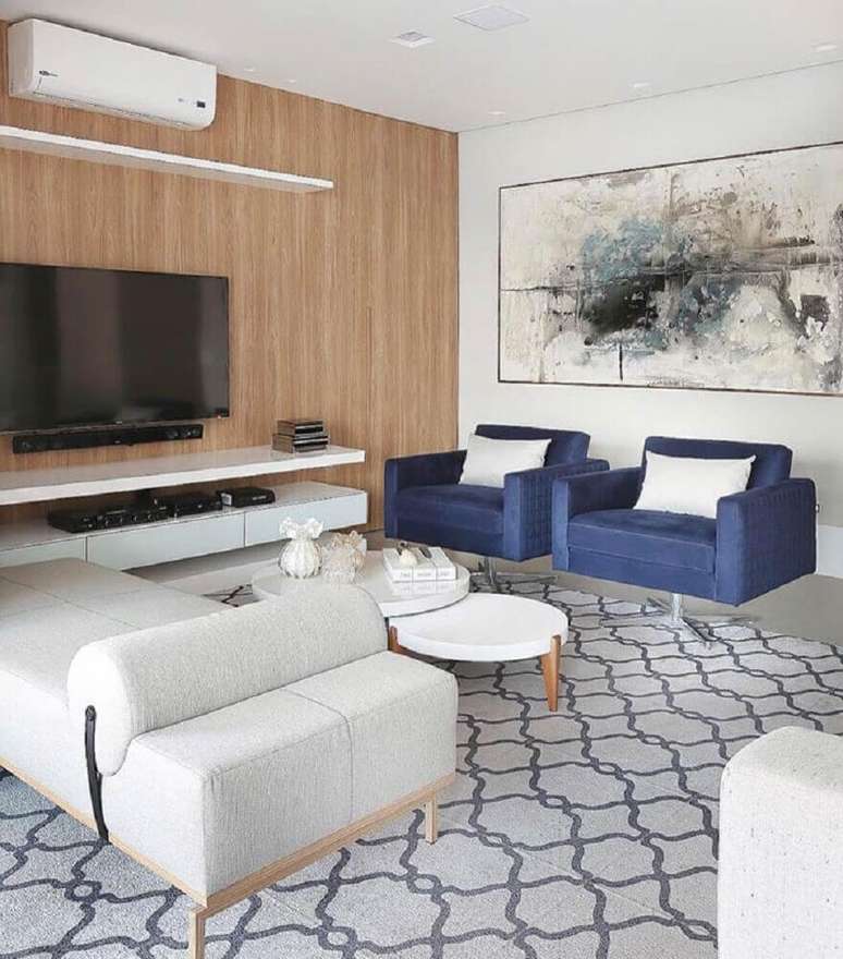 34. Quadros decorativos grandes para sala de estar com poltrona azul e parede revestida de madeira
