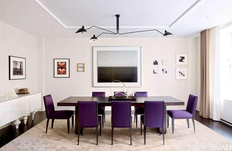 53. Sala de jantar com cadeiras roxas e quadros decorativos nas paredes