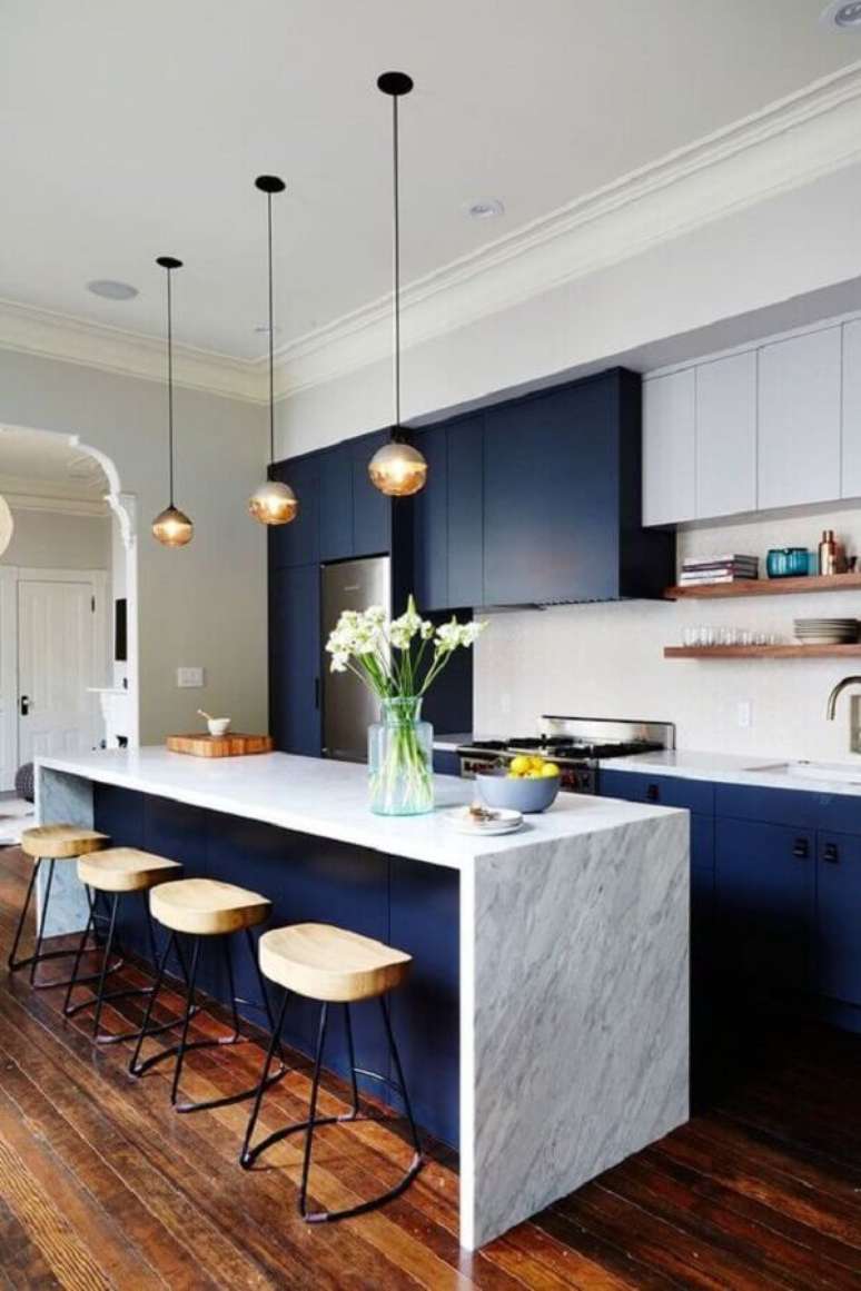 29. Cozinha moderna com armários azul marinho, pendentes modernos e ilha com mármore branco – Foto: Contemporist