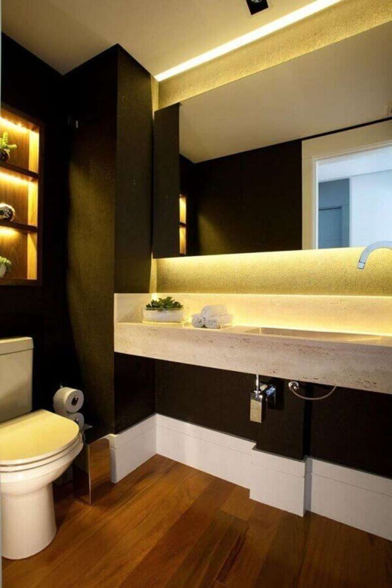 33. Decoração para banheiro com paredes pretas, piso de madeira e bancada em mármore travertino – Foto Liliana Zenaro