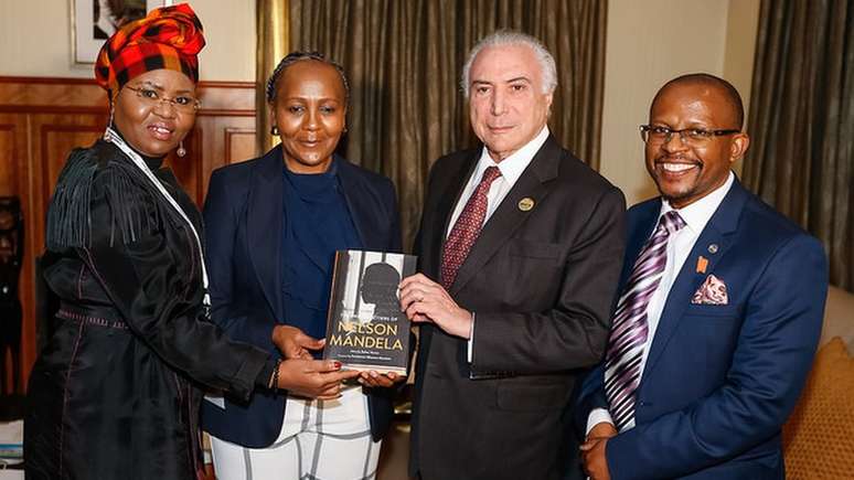 Com índices de reprovação históricos, Temer avaliou que foto com algum membro da família de Nelson Mandela faria bem a sua imagem: na foto, ele posa com a ministra de desenvolvimento de pequenos negócios, Lindiwe Zulu (à esquerda), com Ndileka Mandela, Neta de Mandela, e com o CEO da Fundação Mandela, Sello Hatang