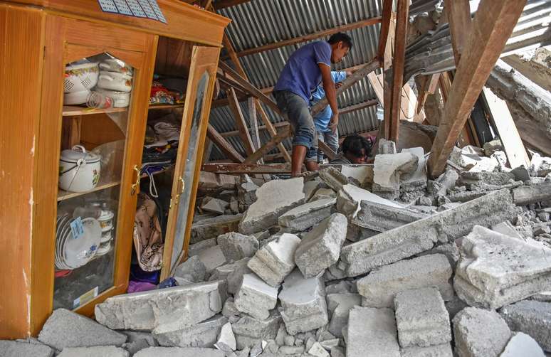 Aldeão caminha pelas ruínas de sua casa após terremoto atingir ilha da Indonésia