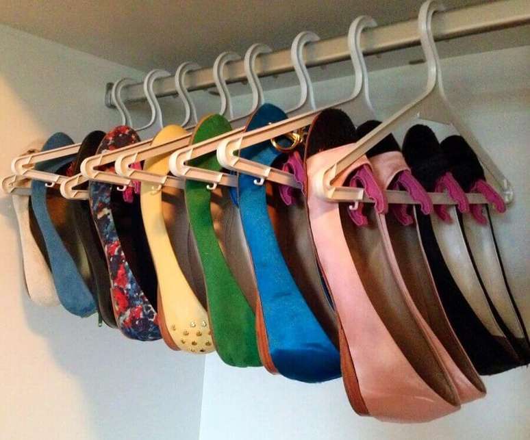 35. Veja essa ideia de como organizar sapatos no guarda roupa utilizando suportes para cabide