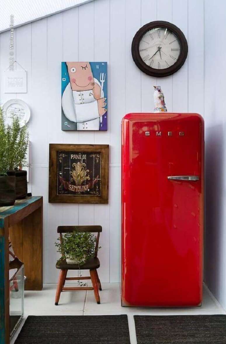 9. Decoração com geladeira vermelha com design antigo e quadros retrô para cozinha – Foto: Rico Mendonça