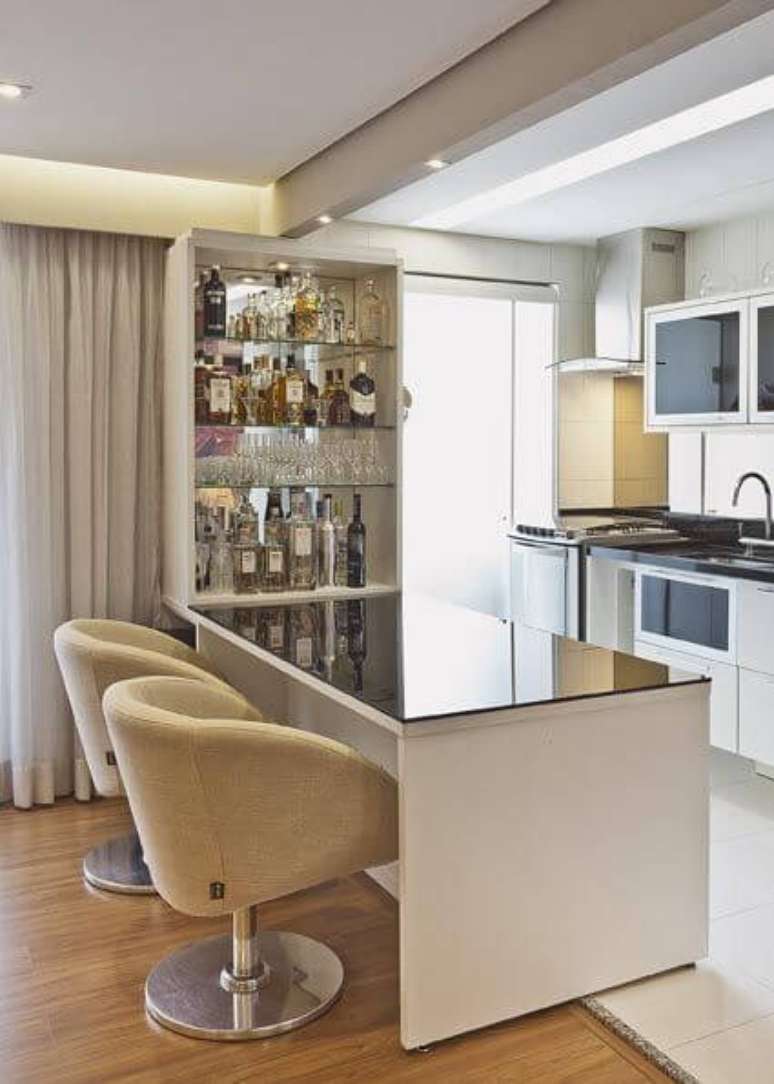 5. O bar de parede pode ser usado para aproveitar o espaço da divisão entre sala e cozinha. Projeto de Renata Tolentino