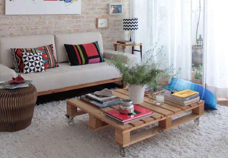 3. Decora&ccedil;&atilde;o r&uacute;stica para sala com parede de tijolinho e mesa de centro feita de pallets &ndash; Foto: UOL