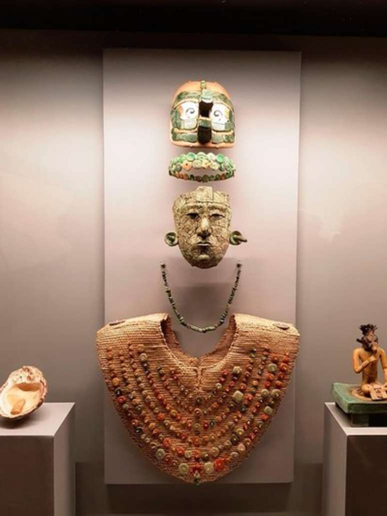 O enxoval funerário da Rainha Vermelha é composto por sete peças: máscara, tiara, colar, peitoral, cocar, concha e estatueta