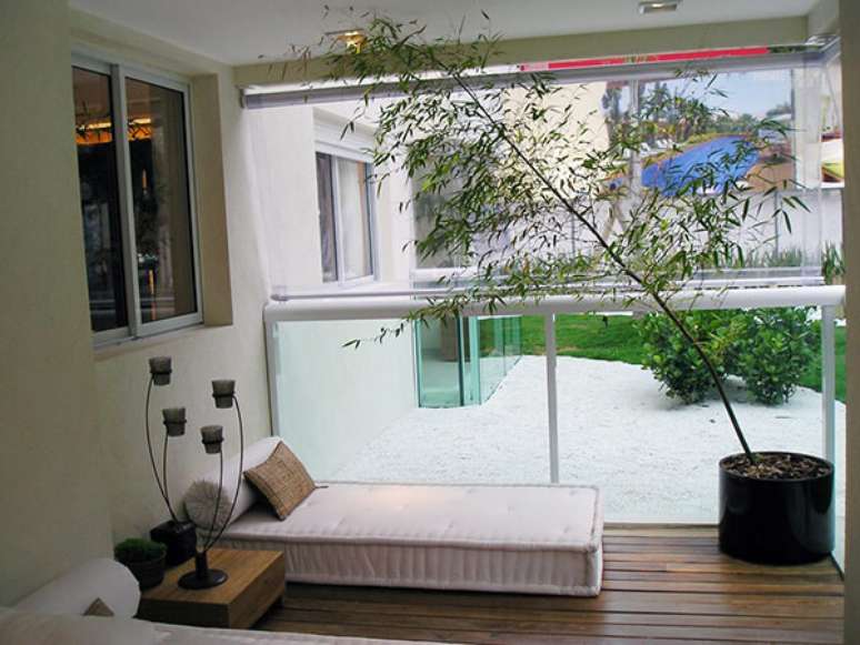 25- Varanda decorada com futtons e vaso redondo preto com bambu moss&ocirc;. Fonte: Verde Vaso