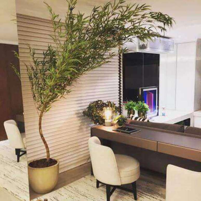 27- O Home Office é decorado com poltronas, persianas e tapete com o vaso bambu da mesma cor. Fonte: Imgrum