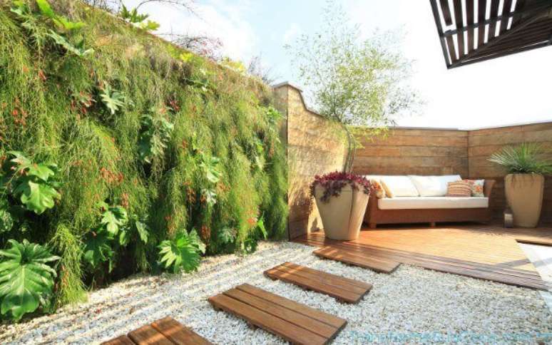 35- No jardim, o deck é decorado com sofá de fibra e um grande vaso com bambu mossô. Fonte: Transforme sua casa