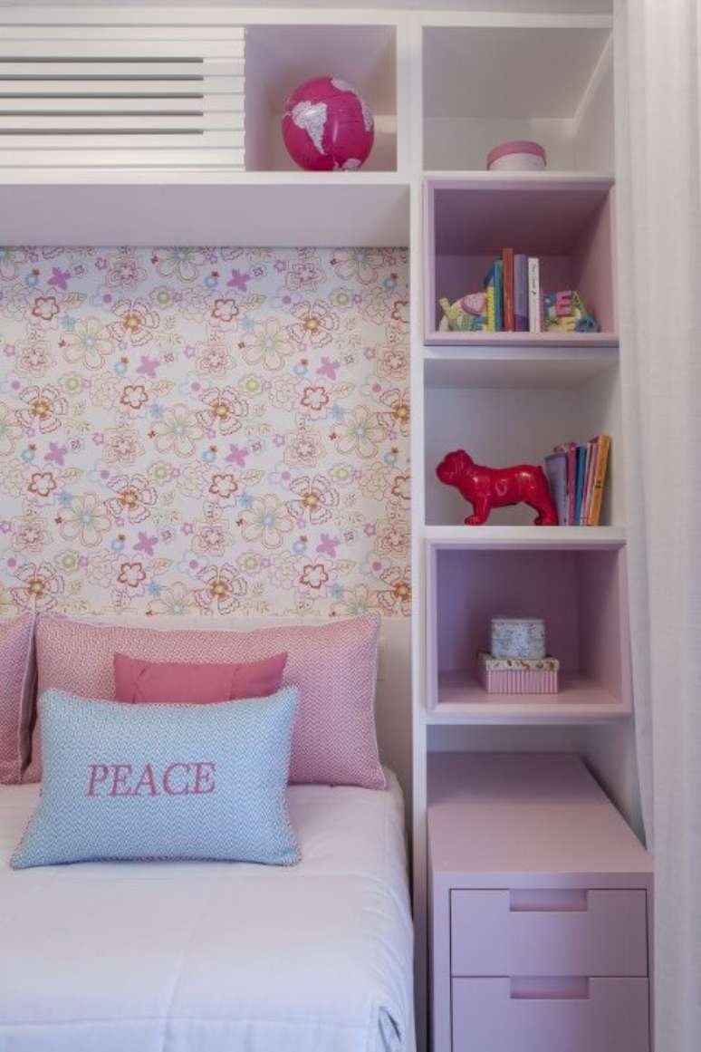 48. Quarto de menina com papel de parede florido e móveis e objetos decorativos em tons de rosa. Projeto de Ark2 Arquitetura