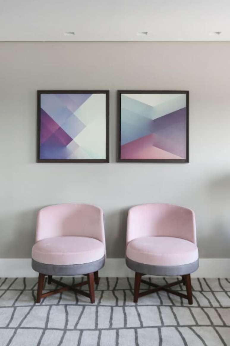 59. Sala de estar com quadros geométricos e poltronas em tons de rosa e cinza. Projeto de Karen Pisaca