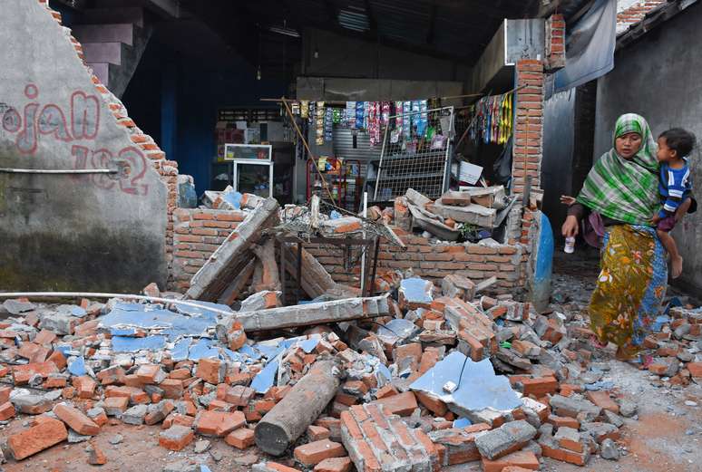 Mulher passa por destroços de parede destruída por forte terremoto em Lombok, na Indonésia 06/08/2018 Antara Foto/Ahmad Subaidi/ via Reuters