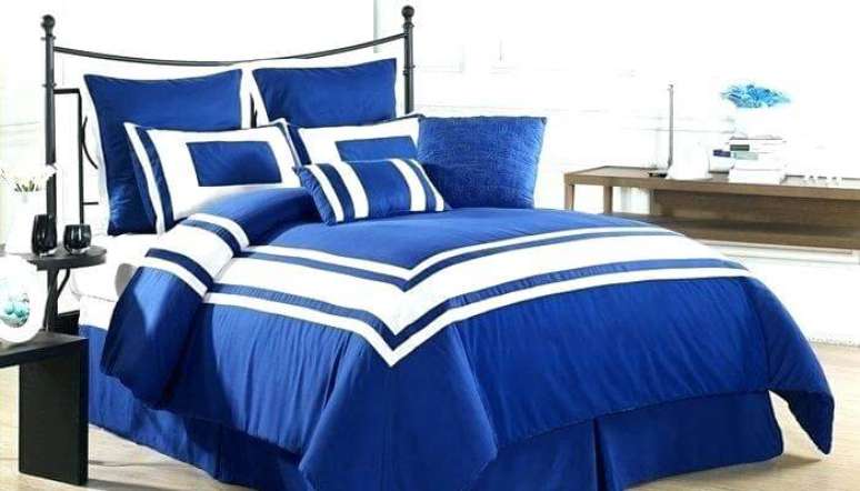 13. Cama com roupa de cama azul royal. Foto de Curlyque