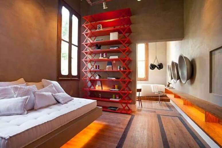 20. Decoração moderna para quarto com parede de cimento queimado e estante vermelha – Foto: Pinterest
