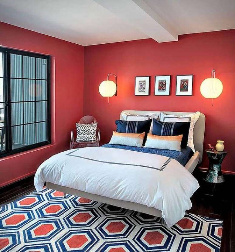56. Decoração para quarto vermelho com tapete estampado e luminárias de parede ao lado da cama – Foto: Lauren M. Levine Interiors
