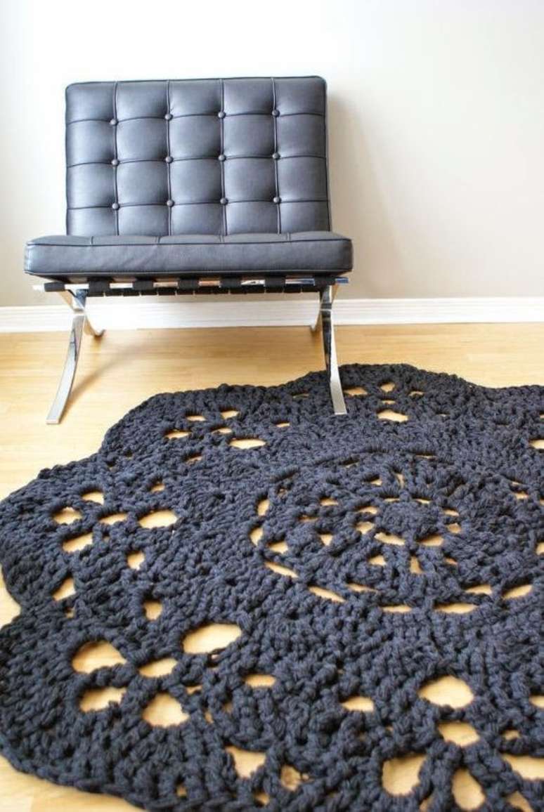 30. Um tapete de croch&ecirc; preto combina perfeitamente com poltronas de couro