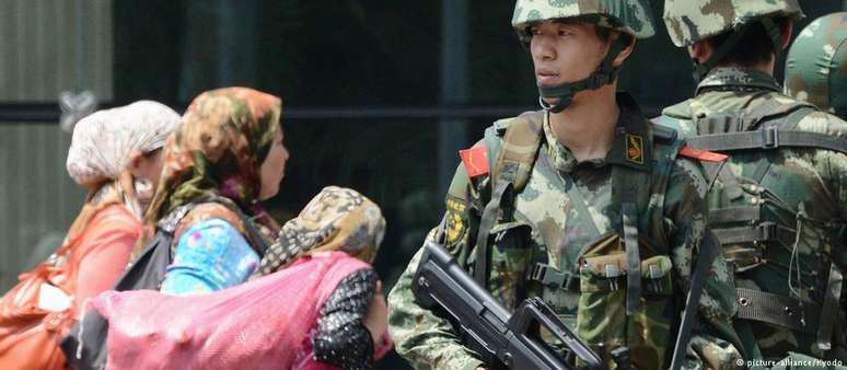 Policiais chineses patrulham bazar na província autônoma uigur de Xinjiang