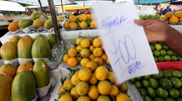 Vendedor segura placa com pre&ccedil;o de fruta em feira de S&atilde;o Paulo 09/12/2015 REUTERS/Paulo Whitaker