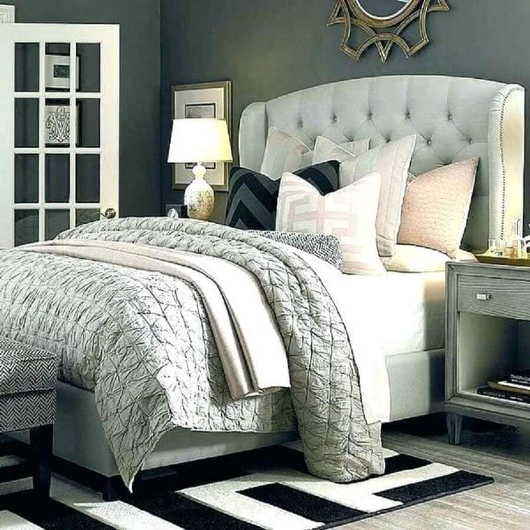 28. Quarto decorado em tons de cinza com tapete preto e branco e cabeceira capiton&ecirc; casal &ndash; Foto: Papagarden