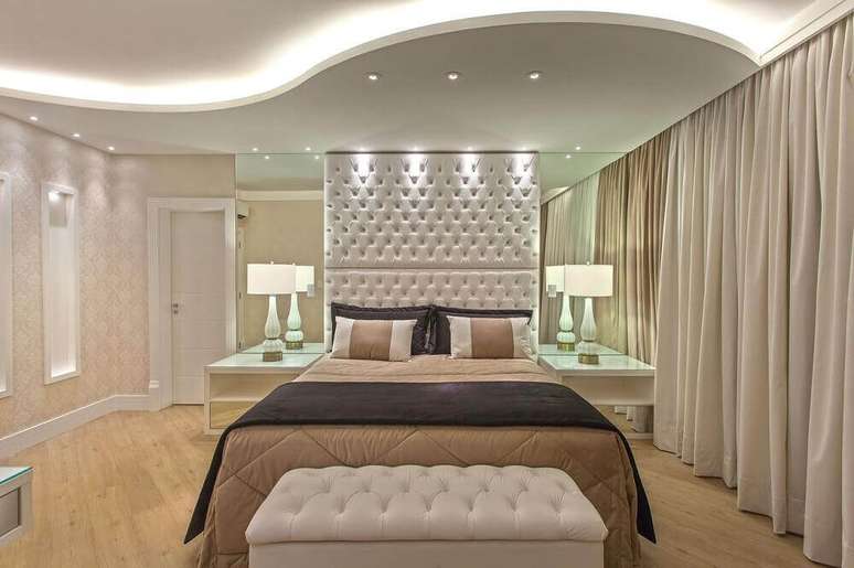 39. A cabeceira queen capiton&ecirc; &eacute; perfeita para quarto com decora&ccedil;&atilde;o sofisticada com parede espelhada &ndash; Foto: Iara Kilaris