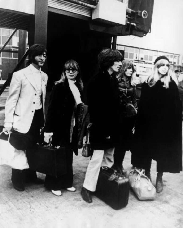 John Lennon e George Harrison são fotografados deixando o aeroporto de Heathrow, em Londres, a caminho a Rishikesh, em 1968