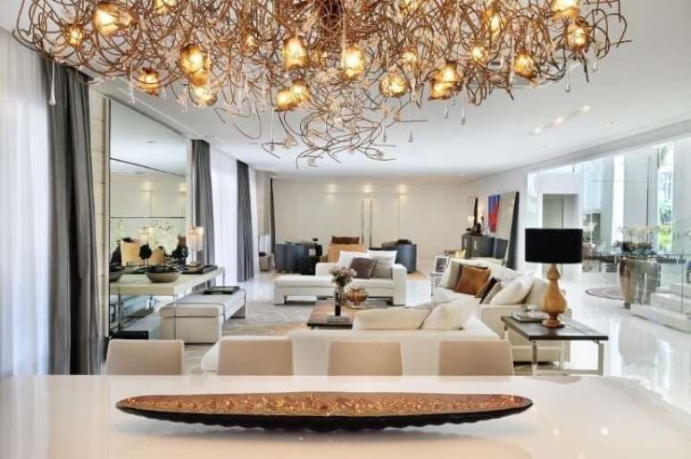 48. Aqui &eacute; o contr&aacute;rio: enquanto o c&ocirc;modo &eacute; bem neutro, o lustre &eacute; cheio de detalhes. Projeto de Quitete Faria