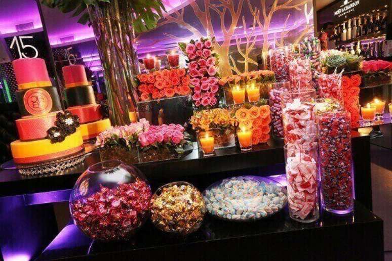 28- Na festa de 15 anos neon, os doces confeitados podem ter a inicial da aniversariante. Foto: Revista Donna