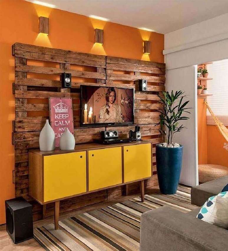 25. Decoração para sala com painel para TV de pallet e rack retrô amarela – Foto: Brettseng Photo