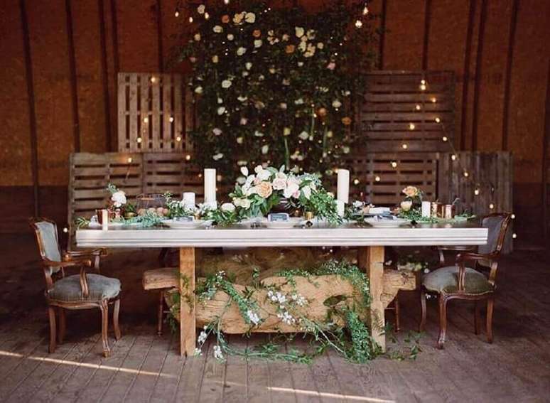 29. Para um casamento mais simples e rústico, invista em um painel de pallet para festa decorado com bastante flores – Foto: Viva Decora