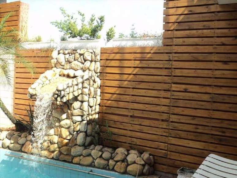 2. Decoração para área externa com piscina e painel de pallet revestindo a parede – Foto: Pinterest