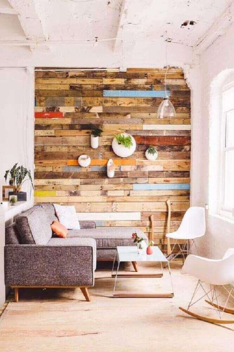 56. Sala clean decorada com móveis estilo escandinavo e parede revestida com pallets – Foto: Pinterest