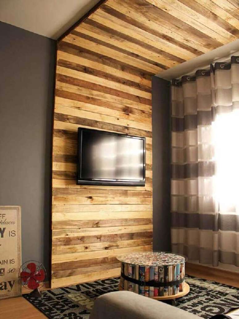 6. Decoração moderna para sala com painel de paletes para TV que se estende até o teto – Foto: Pínterest