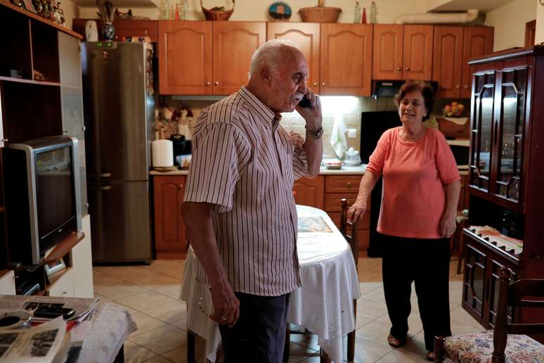 Yorgos Vagelakos, 81 anos, fala ao telefone com neto, ao lado da esposa, Anna, na casa em Keratsini, Atenas 14/8/2018  REUTERS/Alkis Konstantinidis
