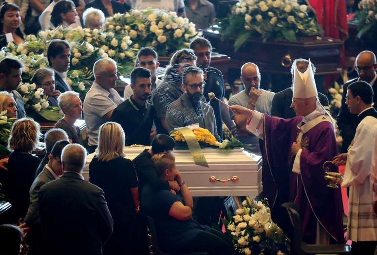O arcebispo de Gênova, cardeal Angelo Bagnasco, abençoa o caixão durante o funeral de Estado das vítimas do desmoronamento da ponte Morandi