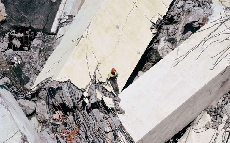 Bombeiro trabalha em meio aos destroços de ponto que desabou em Gênova 