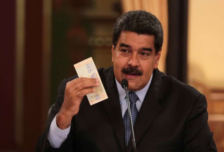 Presidente da Venezuela, Nicolás Maduro, segura nota da nova moeda do país, o bolívar soberano, durante reunião com ministros em Caracas 17/08/2018 Palácio de Miraflores/Divulgação via REUTERS