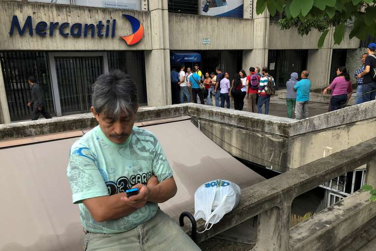 Pessoas formam fila para sacar dinheiro de caixas automático no banco Mercantil, em Caracas
21/08/2018
REUTERS/Carlos Garcia