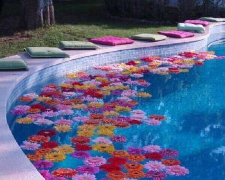 29- A festa havaiana é decorada com almofadas coloridas ao redor e hibiscos coloridos que boiam sobre a água. Fonte: Dcore você