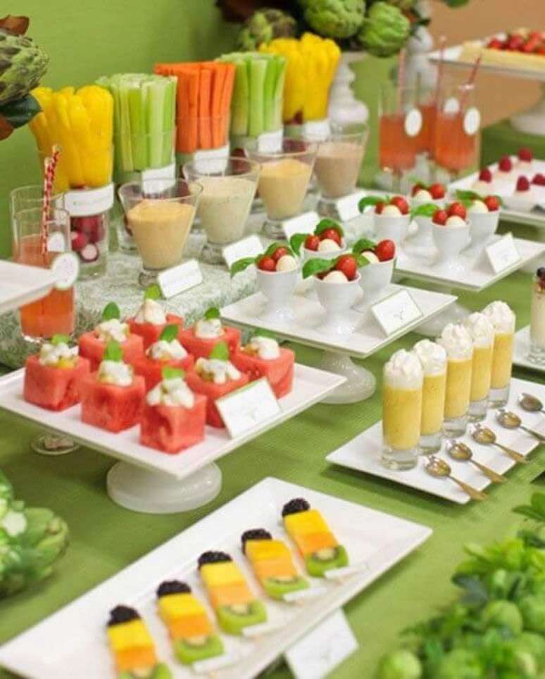 63- A disposi&ccedil;&atilde;o dos doces coloridos na mesa s&atilde;o real&ccedil;ados pela toalha branca em festa havaiana. Fonte: Leather finish