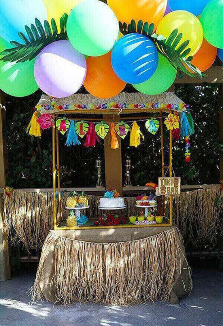 70- Quiosque com saia de palha abriga doces e o bolo em festa havaiana. Fonte: A minha festinha