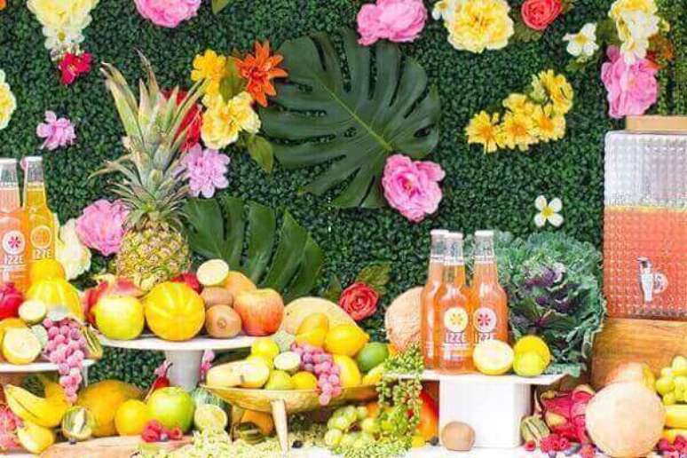 75- A mesa de bebidas e sucos de festa havaiana é enfeitada com muitas frutas. Fonte: We Share Ideas.