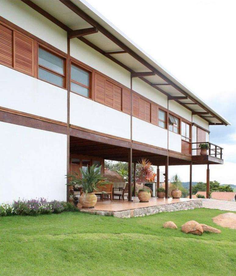 59. Modelo de casa com Fachada com detalhes em madeira na estrutura e janelas