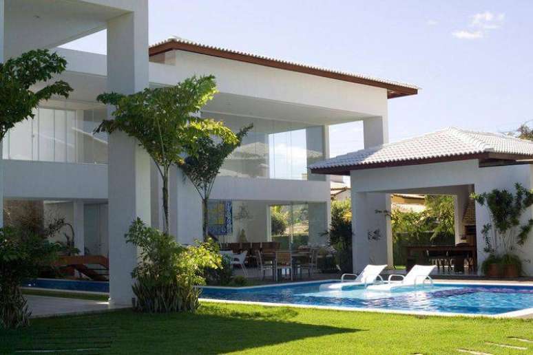 99. Diversos modelos de casas grandes  com piscina são pintadas na cor branca.