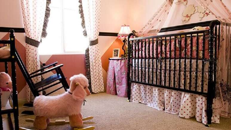 61- A decoração de quarto de bebê menina rosa com berço a cadeira com estrutura preta. Fonte: Westwing