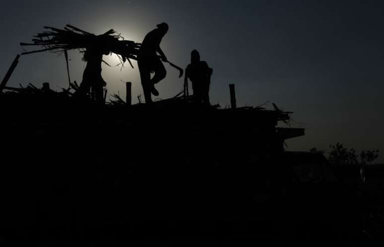 Homens carregam caminh&atilde;o com cana-de-a&ccedil;&uacute;car
04/08/2011
REUTERS/Beawiharta