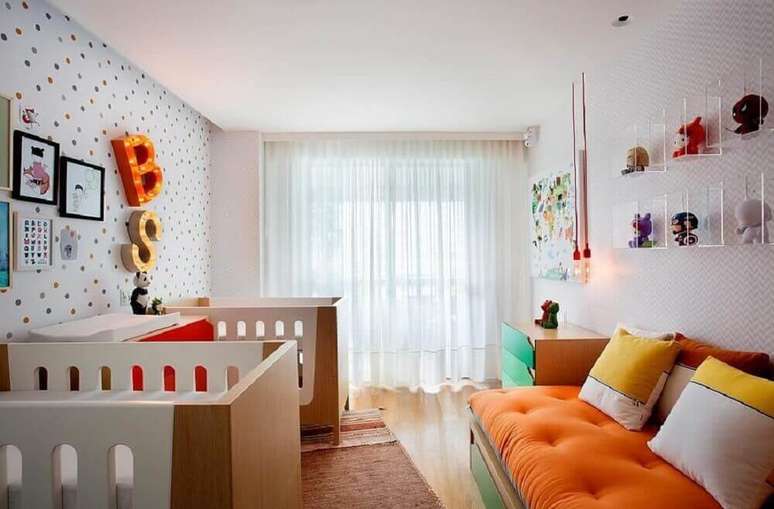31. Decora&ccedil;&atilde;o colorida e moderna para quarto de beb&ecirc; g&ecirc;meos com papel de parede de bolinhas e nichos de acr&iacute;lico &ndash; Foto: Cesar Valenccia