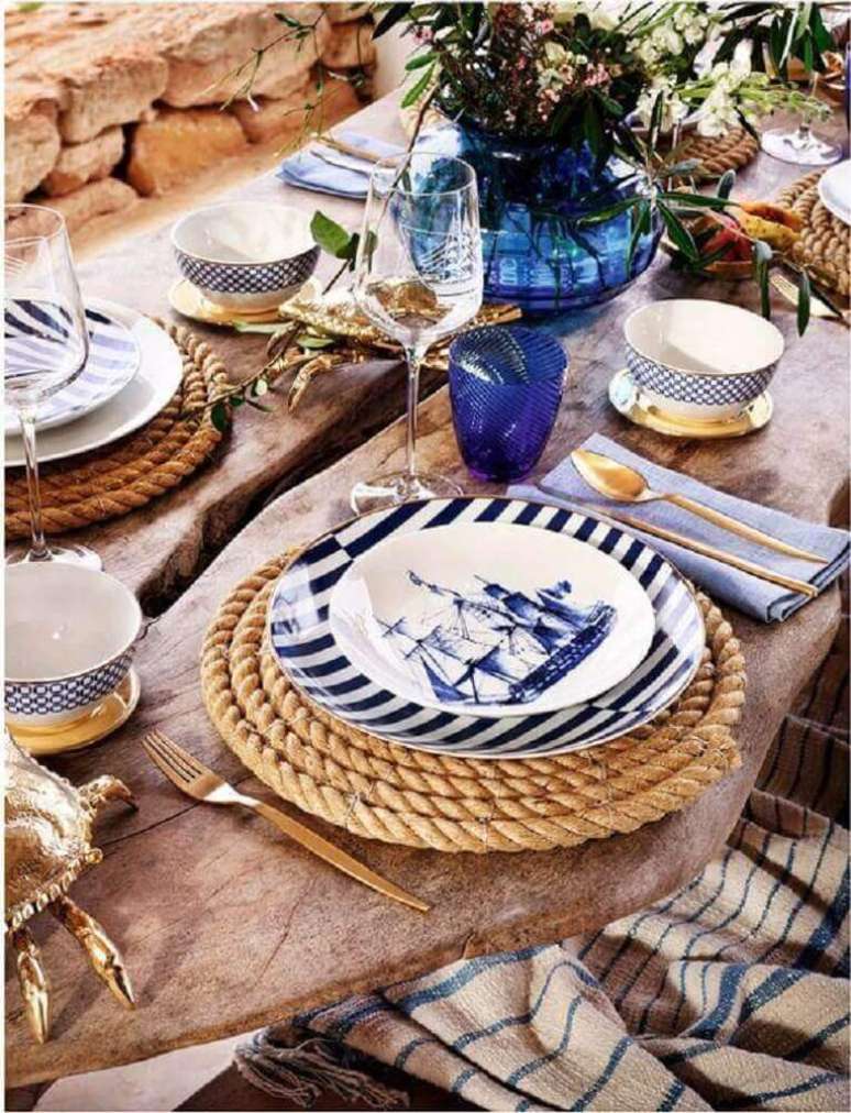 39. Inspiração linda para decoração de mesa rústica em tons de azul e dourado com sousplat de corda