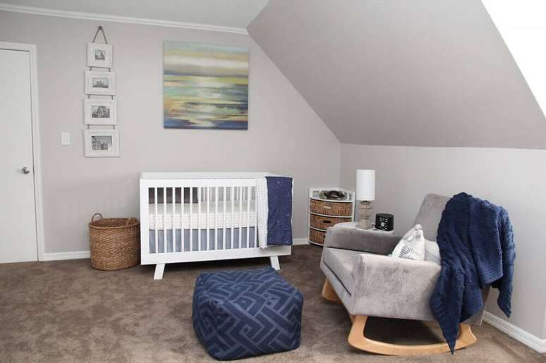 58. Decoração de quarto de bebê simples com berço branco, quadros na parede e poltrona de amamentação cinza – Foto: Plane Pretty
